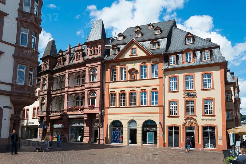 Multi-storey historic buildings with red facades and shutters surround a lively town square, Hauptmarkt, Trier, Rhineland-Palatinate, Germany, Europe