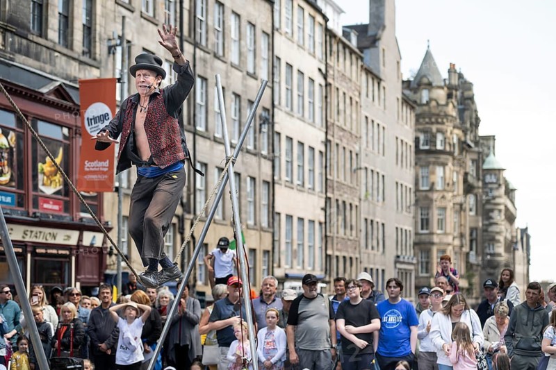 Street performers and spectators at a high-wire acrobatics performance, world's largest cultural festival The Fringe, High Street, Edinburgh, Scotland, United Kingdom, Great Britain, Europe