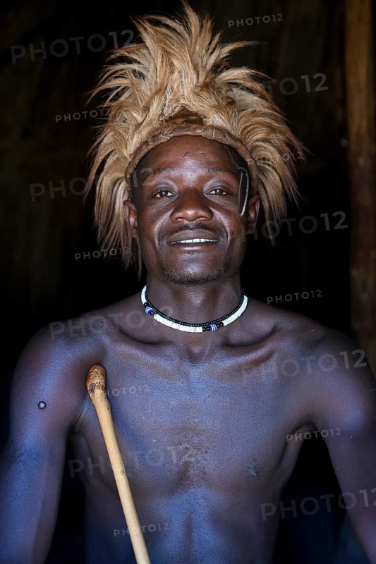 Young Himba man in his hut, Ohandungu, Kunene region, Kaokoveld, Namibia, Africa