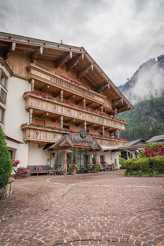 Rustic hotel in the Alps with wooden balcony and colourful floral decorations, Mayrhofen, Zillertal, Austria, Europe