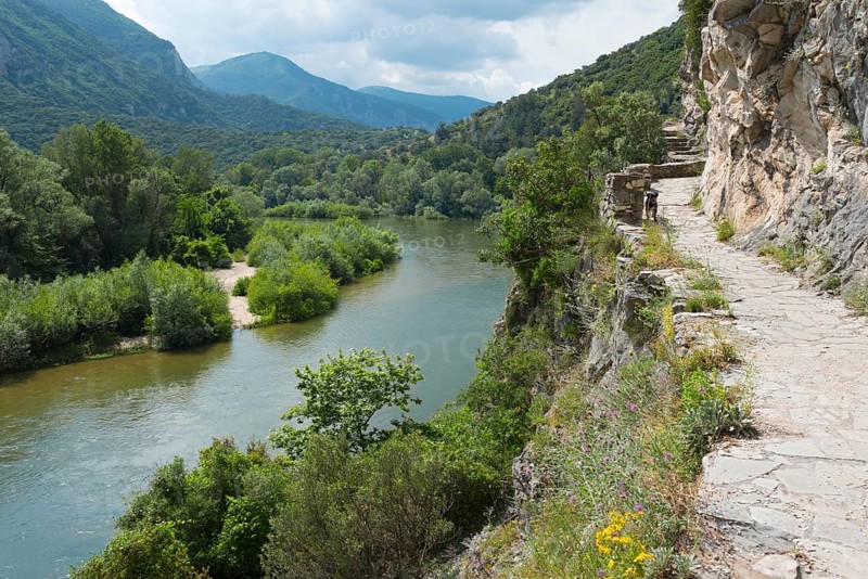 A rocky hiking trail along the bank of a river with surrounding mountain views, River Nestos or Mesta, Nestos Gorge, Galani, Macedonia and Thrace, Greece, Europe