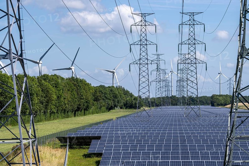 High-voltage power line route, the space underneath is used for a solar park over 5 km long, behind it a wind farm, in the harbour area of Vlissingen-Oost, Netherlands
