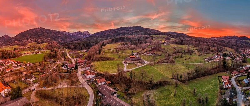 Panoramic view of a village in a hilly landscape at sunset with a red-coloured sky, Bad Feilnbach