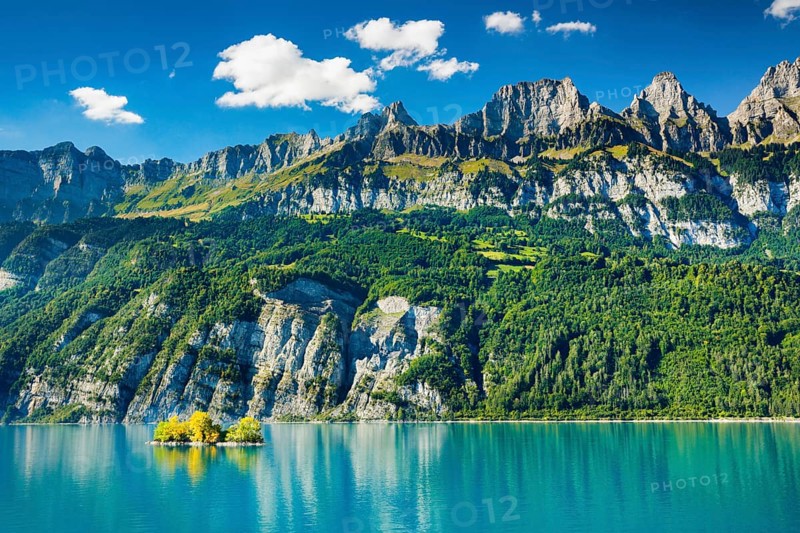 Sunny view over Lake Walen with the small chive island in the turquoise-coloured water at the foot of the Churfirsten Frümsel, Brisi and Zuestoll, Canton St. Gallen, Switzerland, Europe
