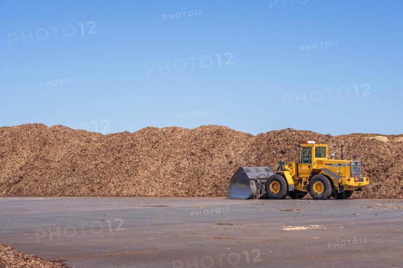 Loader at stacks of Woodchips on a loading area