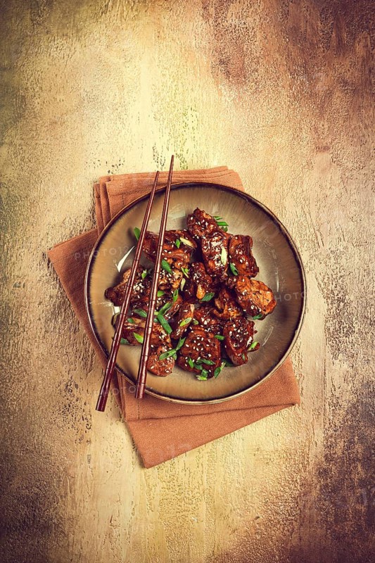 Yakitori chicken kebab, on a plate, with green onions and sesame seeds, top view, no people