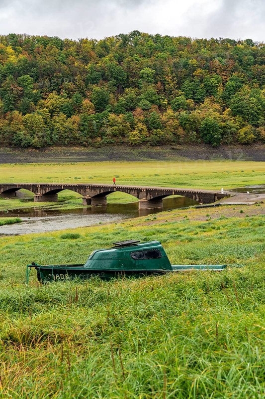 The Edersee, near Waldeck, the third largest reservoir in Germany, currently has only just under 13% of its normal level, the lake was last full in May 2022, dried out due to lack of rain, Asel bridge, exposed by the low water, stranded fishing boat, otherwise flooded, the lake shore and the lake bottom is overgrown with fresh grass, Hesse, Germany, Europe