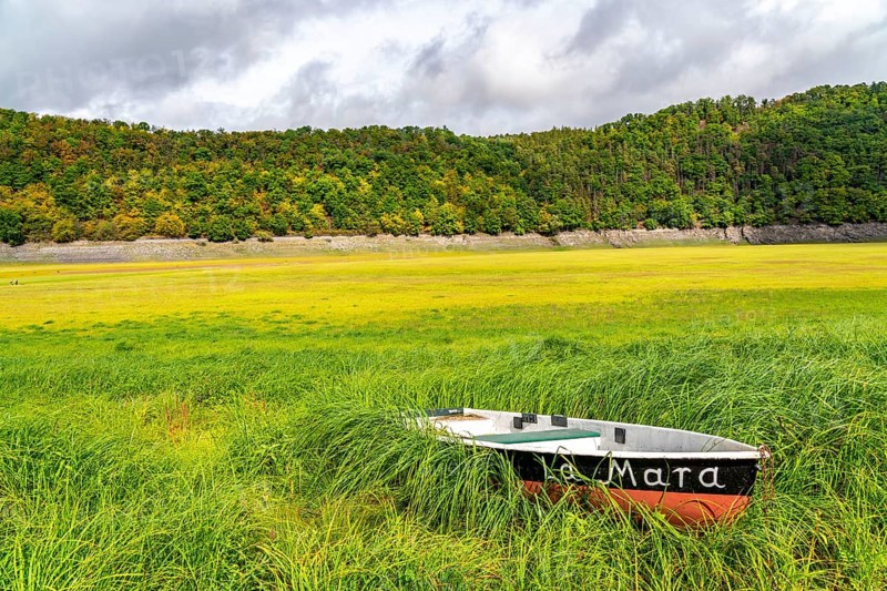 The Edersee, near Waldeck, the third largest reservoir in Germany, is currently only 13% full, the lake was last full in May 2022, dried out due to lack of rain, stranded rowing boat, La Mara, the lake shore and the lake bottom is overgrown with fresh grass, Hesse, Germany, Europe