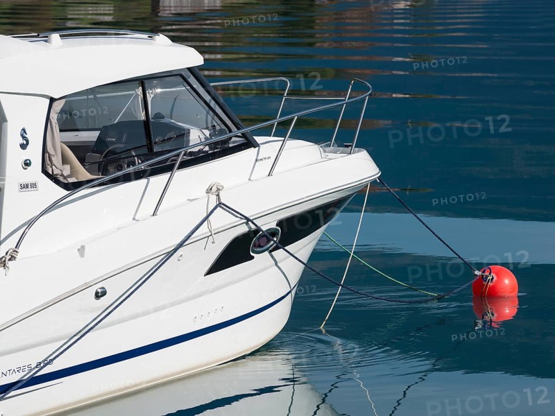 White motorboat, anchors in the fjord, bay of village Solvorn, Lustrafjord, Sognefjord, Norway, Europe