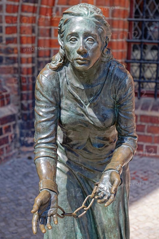 Grete-Minde monument in front of the historic town hall in the old town centre of Tangermünde. The bronze sculpture by sculptor Lutz Gaede depicts the patrician daughter Margarete von Minden, who was executed in 1619. The victim of justice is the subject of several works of art. Town hall, Hanseatic town of Tangermünde, Saxony-Anhalt, Germany, Europe