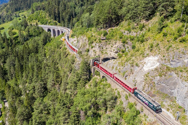 Drone shot of train between Schmittentobel-viadukt and the Landwasserviadukt, near Filisur, red train of Bernina Express, Switzerland, Europe