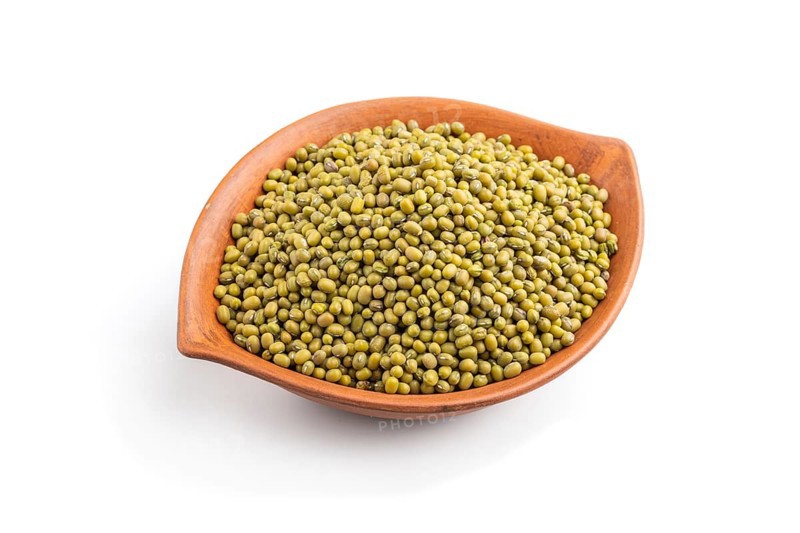 Clay bowl with raw green mung bean isolated on white background. Side view, close up