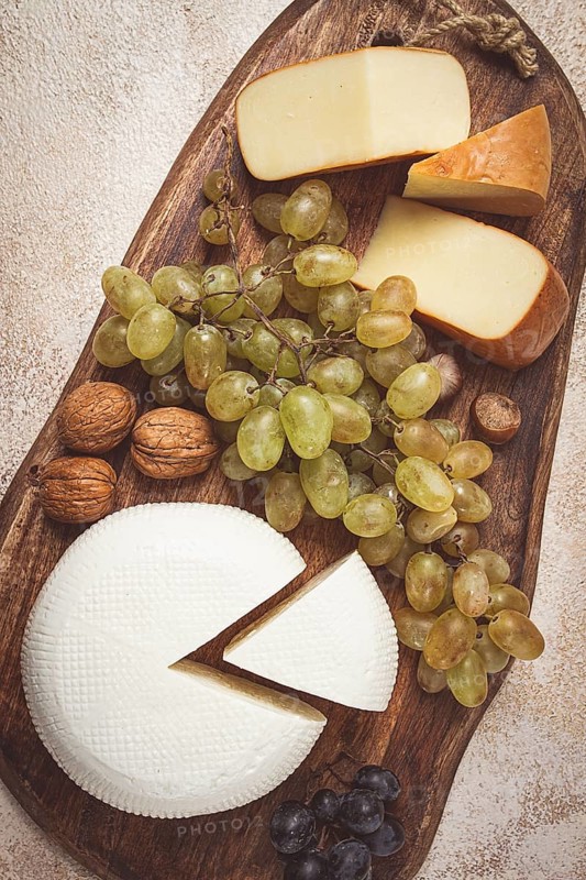 Georgian cheese, Imeretian and smoked suluguni, grapes, nuts, on a cutting board, Georgian cuisine, no people