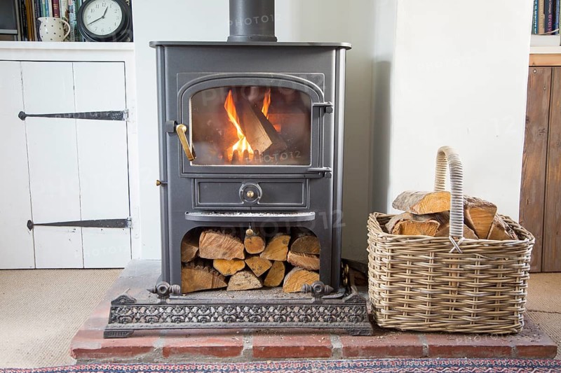 Warm fire flames logs burning in ClearView domestic multifuel stove burner inside home, UK