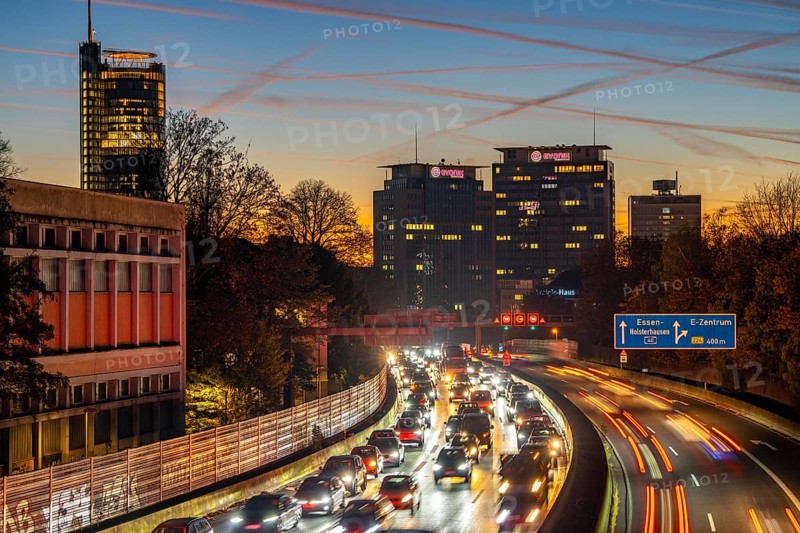 Evening traffic, partly with traffic jams, slow-moving traffic on the A40 motorway, skyline of Essen, left RWE tower, centre Evonik Group headquarters, Essen, North Rhine-Westphalia, Germany, Europe