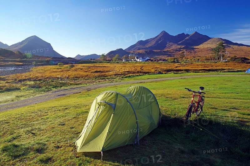A tent and a bicycle stand on a green meadow with mountains in the background, ideal for camping, October, Slichigan, Cullins, Hebrides, Isle of Skye, Hebrides, Scotland, United Kingdom, Europe