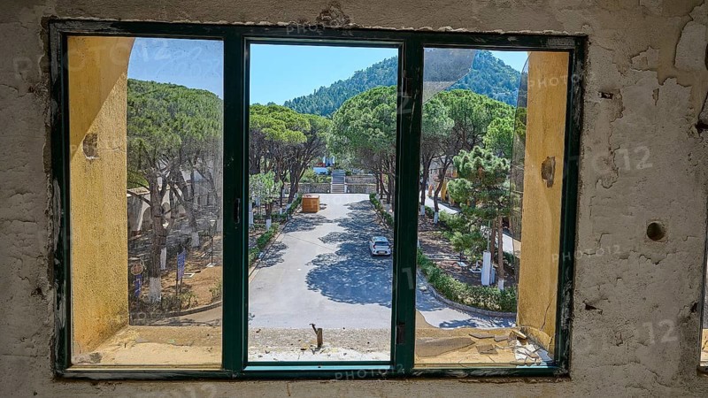 View from a window in an abandoned building onto a green forest landscape and street, Lost Place, Former Santorium, Tuberculosis Centre 1947-1970, Former Italian Colonial Settlement, Eleousa, Campochiaro, Rhodes, Dodecanese, Greek Islands, Greece, Europe