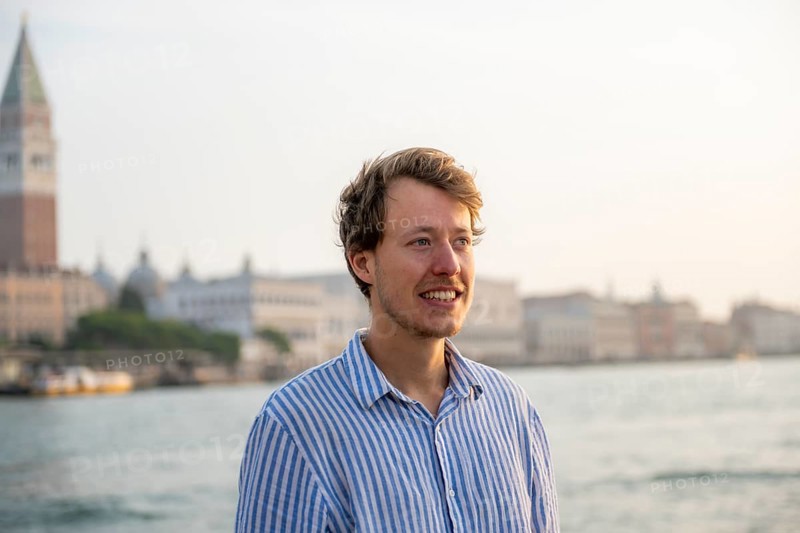 Young man in striped shirt, portrait, on the banks of the Grand Canal, behind Campanile, Venice, Veneto, Italy, Europe