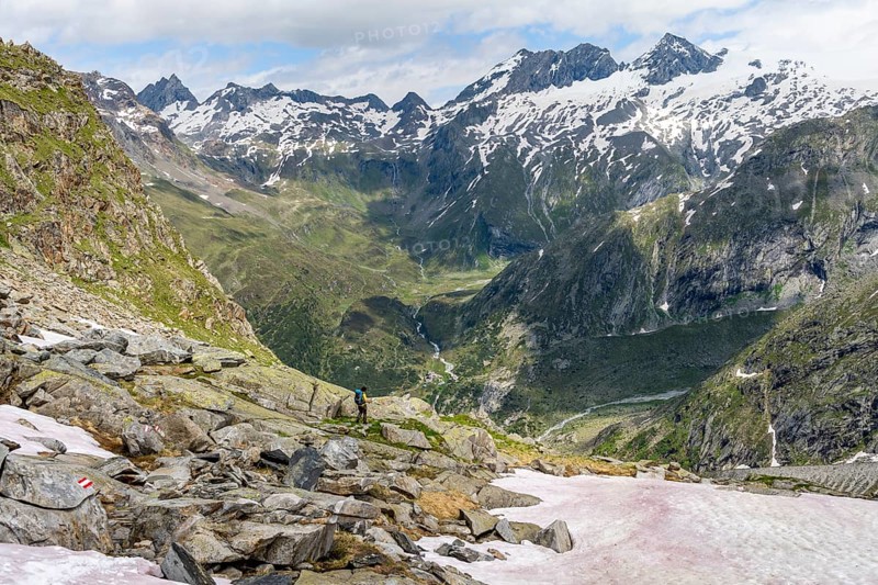 Mountaineer on a hiking trail in front of a picturesque mountain landscape, rocky mountain peaks with glacier and snow, mountain panorama with summit Großer Mörchner, Berliner Höhenweg, Zillertal Alps, Tyrol, Austria, Europe