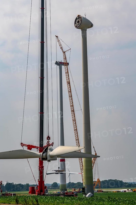 Dismantling of a wind power plant in a wind farm near Issum, 9 older wind turbines from the manufacturer Enercon (model series E-58), front, blades being dismantled, were in operation for over two decades, will be replaced by a total of four Enercon E-160 turbines, rear, assembly of the first blade, with a total output of 22 megawatts, Lower Rhine, North Rhine-Westphalia, Germany, Europe
