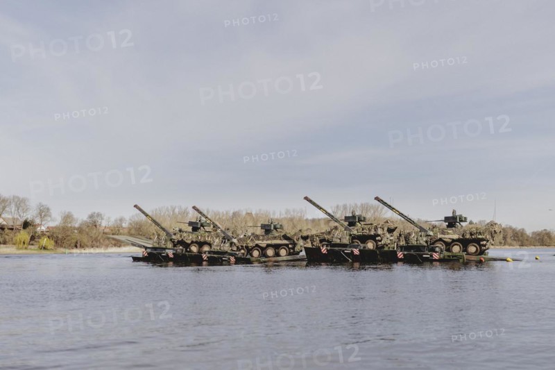 Four Pandur II tanks cross the Elbe with the Bundeswehr's Amphibie M3 floating high-speed bridge as part of the military exercise 'Wettiner Schwert' with German and Czech soldiers near Tangermünde, 26 March 2024. 'Wettiner Schwert' is part of the NATO Quadriga exercise