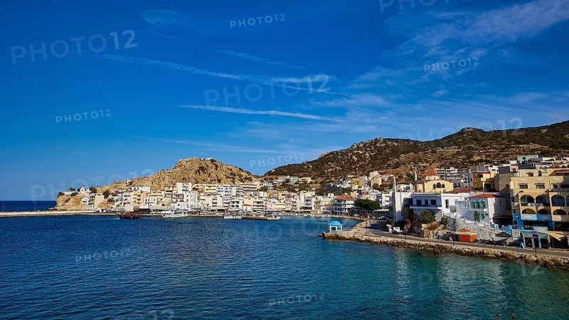 An idyllic coastal town with white buildings and hills, surrounded by blue water under a clear sky, Pigadia, town and harbour, Pigadia Bay, main town, Karpathos, Dodecanese, Greek Islands, Greece, Europe