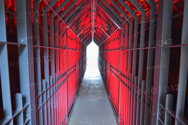 A long tunnel with red lighting and metallic structures conveys a futuristic and industrial atmosphere, Landschaftspark Duisburg Nord, Meiderich Hütte, Duisburg, Ruhr area, North Rhine-Westphalia, Germany, Europe