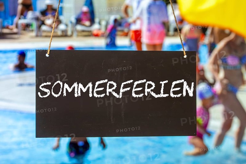 Symbolic image summer holidays: Sign with the inscription SUMMER HOLIDAYS in front of summer holidaymakers in the outdoor pool (Composing)