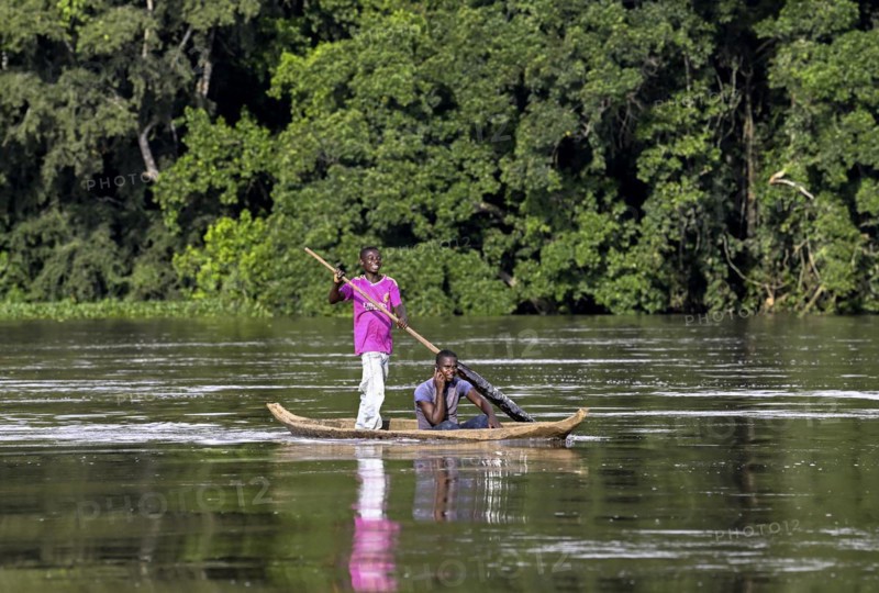 Two young men in a dugout canoe on the Sangha River, Dzanga-Sangha Complex of Protected Areas (DSPAC), Sangha-Mbaéré Prefecture, Central African Republic, Africa