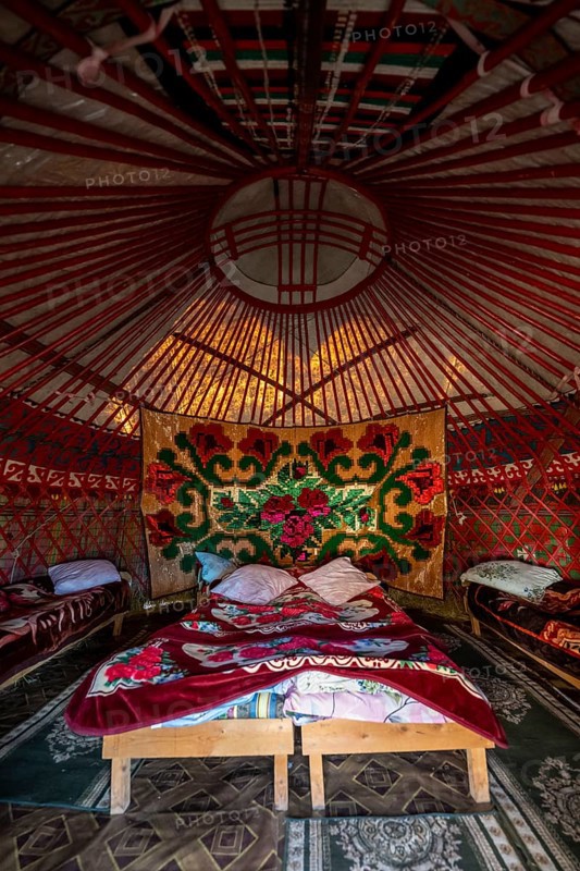 Traditional Kyrgyz yurt for overnight accommodation for tourists, with four beds and carpets, Naryn region, Kyrgyzstan, Asia