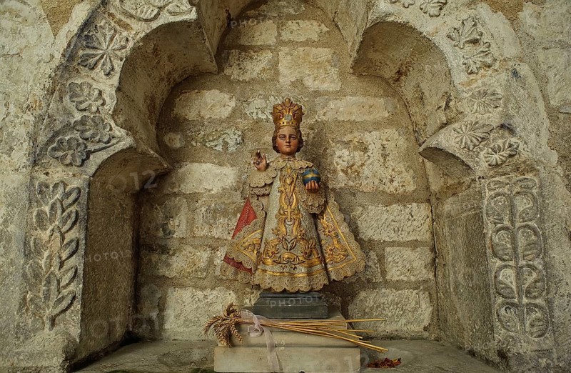 Copy of a statuette representing Jesus Christ as a child. It is called the Little Jesus of Prague. Seen in the Airvault church France