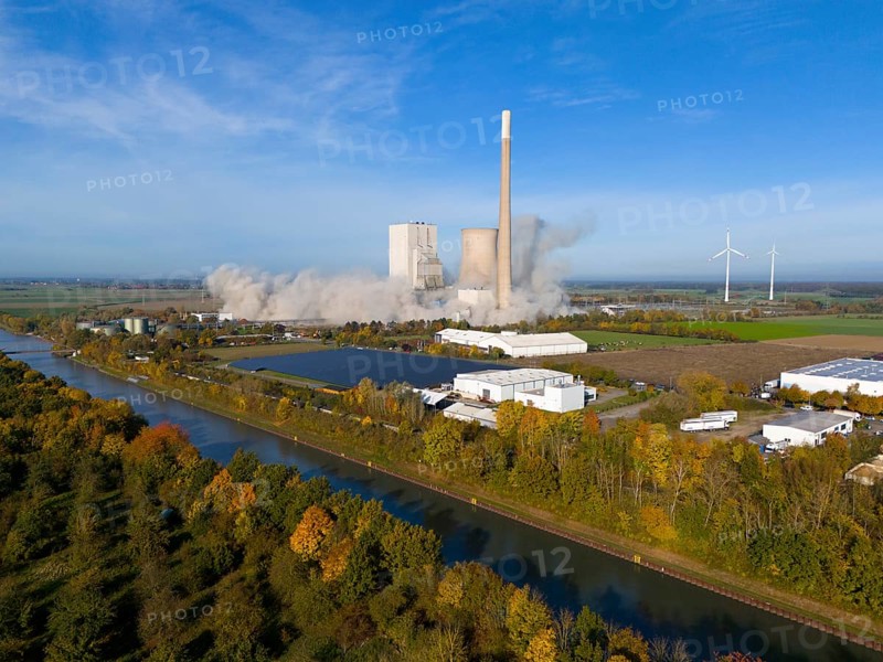 A coal-fired power station with smoking chimneys in a rural setting, surrounded by wind turbines and a canal, blasting of the ash silos, coal-fired power station, Mehrum, Peine district, Mittellandkanal, Lower Saxony, Germany, Europe