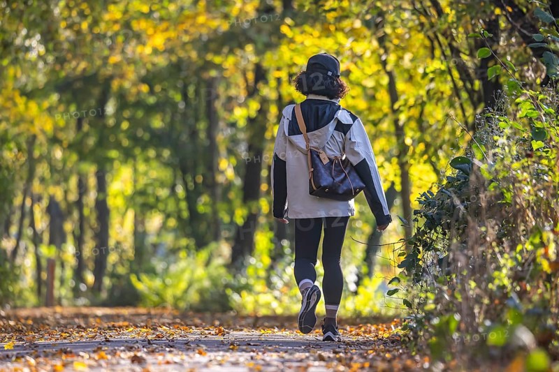 A walk through a colourful autumn forest. A young woman on a circular path on the banks of the Neckar in Stuttgart, Baden-Württemberg, Germany, Europe