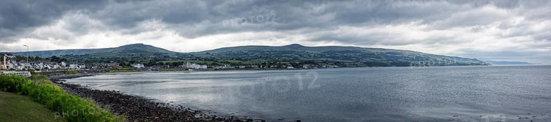 Coastal panorama with mountains in the background and cloudy sky, Ballycastle