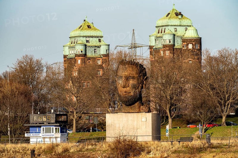 Echo of Poseidon, the 10 m high sculpture by Markus Lüpertz on Mercatorinsel, erected for the 300th anniversary of the harbour, 2016, in the background the bridge towers in Ruhrort, the Friedrich Ebert Bridge over the Rhine, Duisburg, North Rhine-Westphalia, Germany, Europe