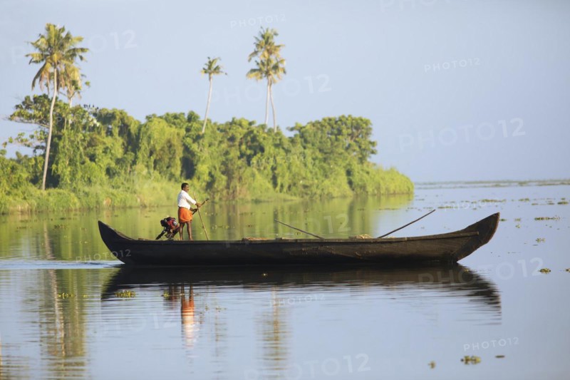 Fisherman in the morning with a boat on the Vembanad Lake, canal system of the backwaters, Kerala, India, Asia