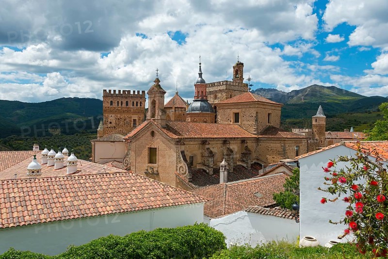 Historische Gebäude mit Ziegeldächern, Bergkulisse und bewölktem Himmel, Wallfahrtskirche und Kloster, Real Monasterio de Nuestra Señora de Guadalupe, Guadalupe, Provinz Cáceres, Caceres, Extremadura, Spanien