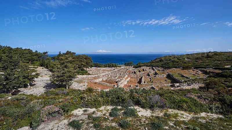 Expansive landscape of ruins overlooking the sea, surrounded by vegetation under a clear blue sky, Kamiros, Archaeological site, Ancient city, Foundation of Doric Greeks, Rhodes, Dodecanese, Greek Islands, Greece, Europe