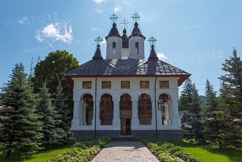 Exterior view of an Orthodox church with white walls and black domes under a clear blue sky, Cheia Romanian Orthodox Monastery, Maneciu, Maneciu, Prahova, Wallachia, Romania, Europe