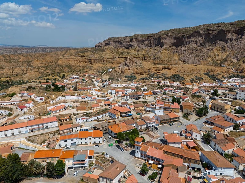 Small village with white houses and red roofs in a rocky hilly landscape under a blue sky, aerial view, Gorafe, Guadix, Granada, Andalusia, Spain, Europe