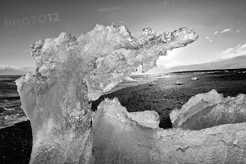 Backlit block of ice, b&w image, beach at glacier lagoon Jökulsarlon, Breiðamerkursandur, south coast, Iceland, Europe