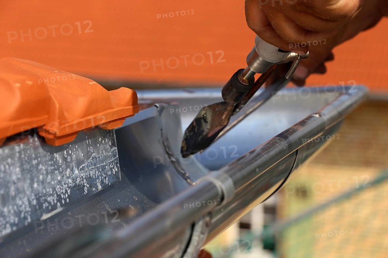 Roofer doing tinsmith work on a gutter