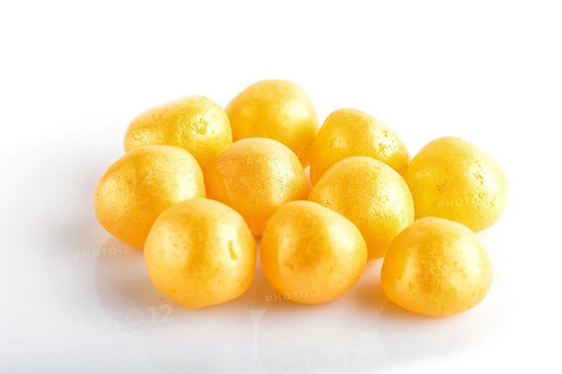 Heap of yellow hard sugar candies isolated on white background