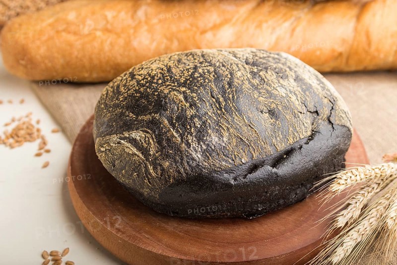 Different kinds of fresh baked bread on a white wooden background. side view, close up, selective focus