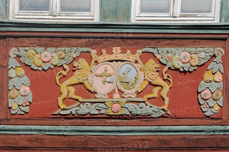 Wood carving of two yellow lion figures with crown at the house Zum goldenen Löwen, detail, colourful floral decorations, painting, arts and crafts, market place, Butzbach, Wetterau, Hesse, Germany, Europe