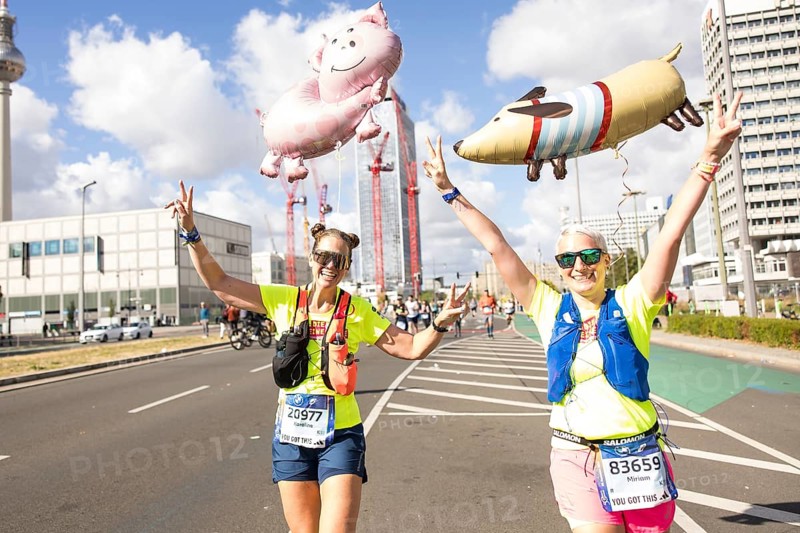 Runners with balloons in the shape of a pig and a dog on Karl-Marx-Allee at the 50th BMW Berlin Marathon 2024 on 29 September 2024