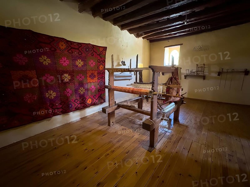 Room with traditional loom left on wall traditionally woven carpet in Xopatera Tower Tower of Xopateras from 19th century in Unesco Site Site Orthodox Greek Orthodox Monastery Moni Odigitria, Festos, Crete, Greece, Europe