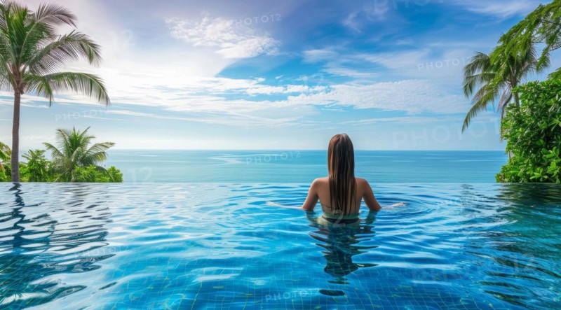 Woman swimming in infinity pool on Caribbean vacation looking at ocean scenic landscape, AI generated