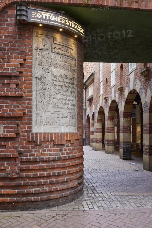 Illuminated sign Böttcherstrasse, sign embedded in the house wall to the artist Paula Modersohn-Becker and brick houses with arcades in the Böttcherstrasse in Bremen, Hanseatic city, state of Bremen, Germany, Europe