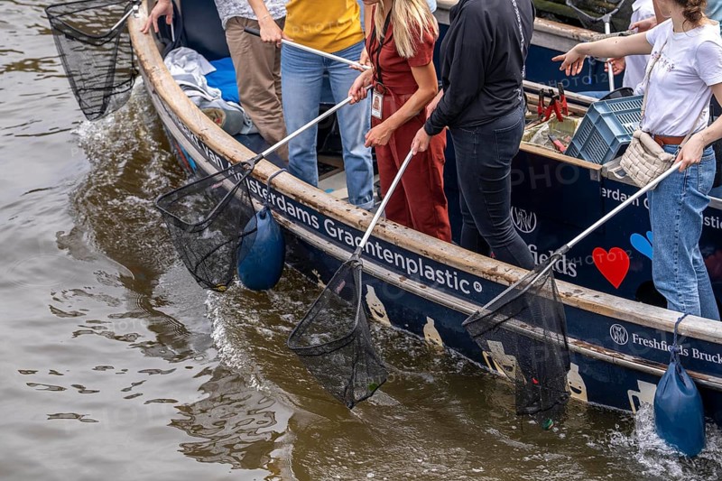 Plastic Whale boat in a canal in Amsterdam, passengers fish plastic waste out of the canals, tour through the canals of Amsterdam, collecting waste as an event, Netherlands